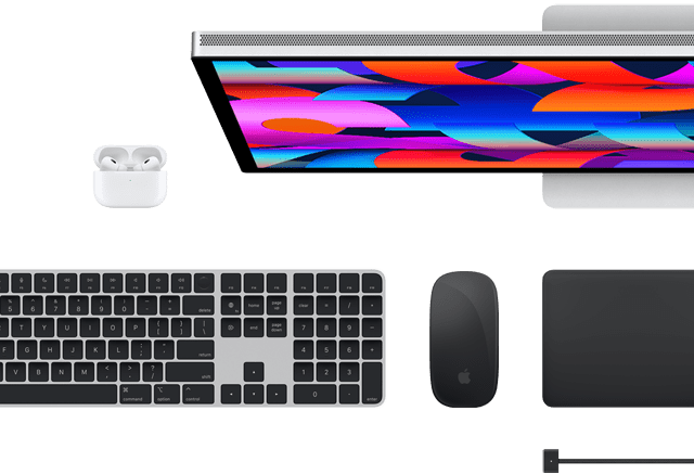 Vista superior de varios accesorios del Mac: un Studio Display, un Magic Keyboard, un Magic Mouse, un Magic Trackpad, unos AirPods y un cable de carga MagSafe